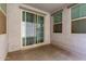 A cozy covered patio with sliding glass doors and sunny windows offers a quiet outdoor space to enjoy the weather at 302 N 69Th Pl, Mesa, AZ 85207