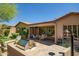 A covered back patio with dining set is adjacent to an outdoor kitchen with a stainless grill at 3336 W Morse Dr, Anthem, AZ 85086