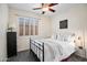 Bedroom with queen bed, black metal frame, soft linens, and sunny window with plantation shutters at 3336 W Morse Dr, Anthem, AZ 85086