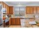 Cozy kitchen featuring wooden cabinetry, granite countertops, and a window view of the lush outdoors at 3336 W Morse Dr, Anthem, AZ 85086