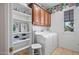 Laundry room with white shelving, overhead wood cabinets, white washer/dryer, and tile flooring at 3336 W Morse Dr, Anthem, AZ 85086