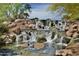 Natural stone waterfall cascading into a clear pond, creating a serene and picturesque outdoor scene at 3336 W Morse Dr, Anthem, AZ 85086