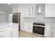 Updated kitchen featuring stainless steel appliances, quartz countertops, white cabinetry, and modern backsplash at 4115 W Sierra St, Phoenix, AZ 85029