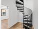 A modern black spiral staircase leading into an open room with light wood floors at 4220 N 32Nd St # 21, Phoenix, AZ 85018