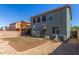 Exterior view of home with backyard featuring landscaping and AC units at 45080 W Buckhorn Trl, Maricopa, AZ 85139