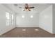 Open bedroom featuring two windows, carpeted floors and ceiling fan at 45080 W Buckhorn Trl, Maricopa, AZ 85139