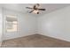 A bright, carpeted bedroom featuring a ceiling fan at 45080 W Buckhorn Trl, Maricopa, AZ 85139