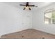 Bright bedroom featuring a ceiling fan, neutral walls, tile flooring, and a closet with sliding doors at 45080 W Buckhorn Trl, Maricopa, AZ 85139