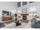 Bright living room with vaulted ceiling, fireplace, modern decor, and lots of natural light at 45080 W Buckhorn Trl, Maricopa, AZ 85139