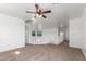 Spacious loft area with neutral carpet, ceiling fan, and a view of the home's interior at 45080 W Buckhorn Trl, Maricopa, AZ 85139