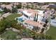 Expansive property featuring a pool, lush green lawn, multiple sports courts and elegant white exterior with a terracotta roof at 6443 E Malcomb Dr, Paradise Valley, AZ 85253