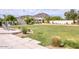 Expansive backyard with lush lawn, mature landscaping, and a hanging chair; mountain views in the distance at 6443 E Malcomb Dr, Paradise Valley, AZ 85253