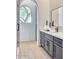 Bathroom with an arched window, gray cabinets, and a view to the outside at 6443 E Malcomb Dr, Paradise Valley, AZ 85253