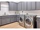Laundry room with gray cabinets, light countertops, stainless washer and dryer, and wood-look floors at 6443 E Malcomb Dr, Paradise Valley, AZ 85253