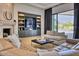 Inviting living room features custom built-ins, a stone fireplace, and a large glass door with outdoor views at 6443 E Malcomb Dr, Paradise Valley, AZ 85253