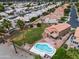 A home featuring a tile roof, in-ground pool, lush green lawn and tropical trees, all captured from above at 665 S Balboa --, Mesa, AZ 85206