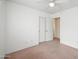 This bedroom features neutral carpet, a ceiling fan, and a closet with white doors at 665 S Balboa --, Mesa, AZ 85206
