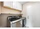 Efficient laundry area with modern washer and dryer, white cabinets, and ample storage space at 665 S Balboa --, Mesa, AZ 85206