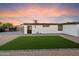 A low-maintenance backyard with a defined artificial turf area and gravel surrounding the house at 7026 E Pasadena Ave, Paradise Valley, AZ 85253