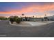 Stylish mid-century modern home with a covered carport, desert landscaping, and mountain views at sunset at 7026 E Pasadena Ave, Paradise Valley, AZ 85253