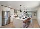 Modern kitchen featuring a waterfall island with seating, stainless steel appliances, and sleek white cabinetry at 7026 E Pasadena Ave, Paradise Valley, AZ 85253