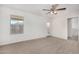 A light-filled bedroom with neutral carpet, ceiling fan, and door to the balcony at 820 E Agua Fria Ln, Avondale, AZ 85323