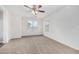 A light-filled bedroom with neutral carpet, ceiling fan, and two windows at 820 E Agua Fria Ln, Avondale, AZ 85323