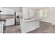 Kitchen includes stainless steel fridge, white cabinets, stone countertops, and dining area at 820 E Agua Fria Ln, Avondale, AZ 85323