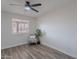 Bright bedroom with wood-look floors, a chair, a leafy potted plant, and a window at 8309 E Rose Ln, Scottsdale, AZ 85250