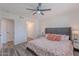 Cozy bedroom features wood-look flooring, a ceiling fan, and a stylish upholstered headboard at 8309 E Rose Ln, Scottsdale, AZ 85250