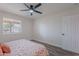 Bedroom featuring a ceiling fan, window, a well-decorated bed, and wood-look tile at 8309 E Rose Ln, Scottsdale, AZ 85250