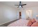 Bright bedroom with wood-look floors, ceiling fan, and doorways to other rooms at 8309 E Rose Ln, Scottsdale, AZ 85250