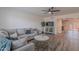 Cozy living room with wood-look tile, ceiling fan, and grey sofa with decorative throw pillows at 8309 E Rose Ln, Scottsdale, AZ 85250