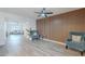 Bright living room featuring wood-look tile, decorative wood wall, and a comfortable seating area at 8309 E Rose Ln, Scottsdale, AZ 85250