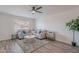 Bright living room featuring ceiling fan, a grey sofa, decorative pillows, and wood-look tile at 8309 E Rose Ln, Scottsdale, AZ 85250