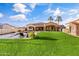 Spacious backyard with a pool, green grass, and patio area at 8325 W Cantera Ave, Peoria, AZ 85383