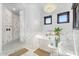 Bright bathroom with soaking tub, walk-in shower, chandelier, and marble floors at 8325 W Cantera Ave, Peoria, AZ 85383