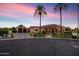 Stunning exterior view of home, featuring palm trees, stucco, and a well-manicured lawn at dusk at 8325 W Cantera Ave, Peoria, AZ 85383
