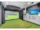 Home golf simulator room featuring a large screen, turf flooring, and modern design at 8325 W Cantera Ave, Peoria, AZ 85383
