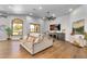 Bright living area featuring hardwood floors, a cozy sofa, large windows, and a modern entertainment center at 8325 W Cantera Ave, Peoria, AZ 85383