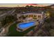 Aerial view of an estate home with a pool, outdoor seating, lush landscaping, and desert mountain views at 9301 E Via Montoya --, Scottsdale, AZ 85255