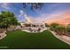 Expansive backyard with lush synthetic grass, pool, travertine patio, and desert landscaping at 9301 E Via Montoya --, Scottsdale, AZ 85255
