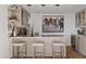 Elegant bar area featuring marble countertops, seating for three, and custom glass shelving at 9301 E Via Montoya --, Scottsdale, AZ 85255