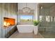 Elegant bathroom features a soaking tub, fireplace, chandelier, and a beautiful view from the window at 9301 E Via Montoya --, Scottsdale, AZ 85255