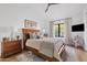A sunlit main bedroom featuring a wooden bed frame, stylish decor, and views to the outdoors at 9301 E Via Montoya --, Scottsdale, AZ 85255