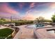 Outdoor entertaining area featuring a pool, spa, manicured desert landscaping, and picturesque sunset views at 9301 E Via Montoya --, Scottsdale, AZ 85255