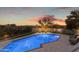 Sparkling pool with a tanning ledge, manicured landscaping, outdoor furniture, and sunset views at 9301 E Via Montoya --, Scottsdale, AZ 85255