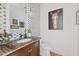 Elegant powder room boasts a dark wood vanity with marble counters and decorative tile accent wall at 9301 E Via Montoya --, Scottsdale, AZ 85255