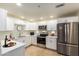 Bright kitchen featuring white cabinets, stainless steel appliances, and tile flooring at 9455 E Raintree Dr # 1025, Scottsdale, AZ 85260