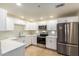 Modern kitchen with stainless steel appliances, white cabinets, and light countertops at 9455 E Raintree Dr # 1025, Scottsdale, AZ 85260